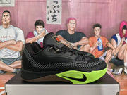 Side profile of a black Nike basketball sneaker with a bright green sole, black swoosh, gray patterned panel, and orange tongue detail.