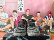 Front view of black and grey basketball shoes with orange lace eyelets