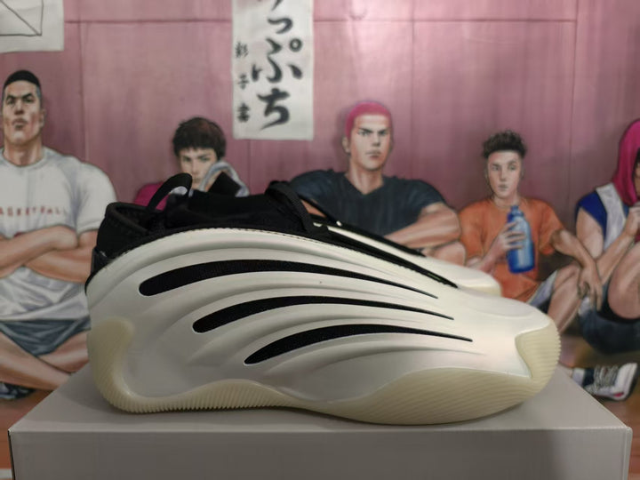 Side view of a white and black sneaker with a sculpted sole and curved black side accents.