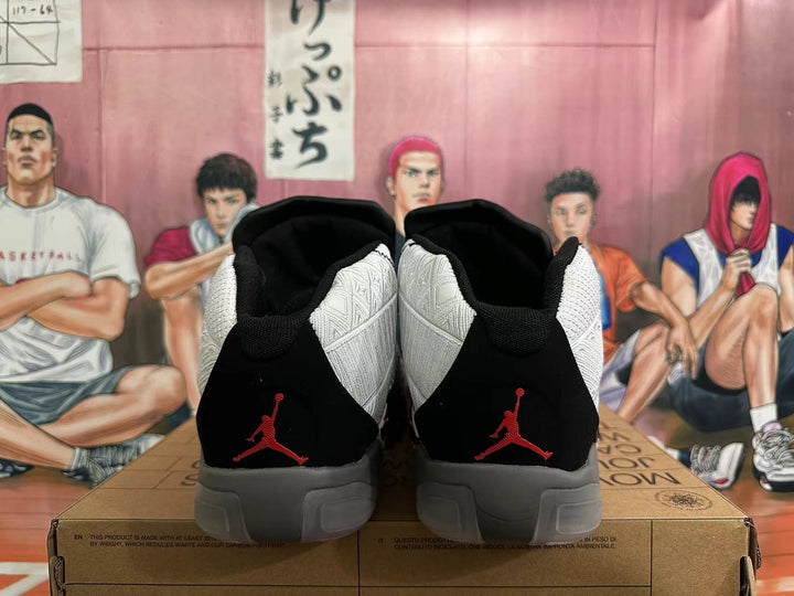 Rear view of white and black high-top basketball shoes with red Jumpman-style heel marks and gray soles.