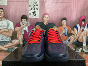 Front view showing the paired sneakers with bright red laces, perforated toe boxes, and yellow tongue accents.