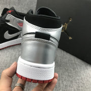 Close-up rear view showing the silver heel panel, black collar and red outsole.