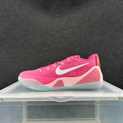 Side view of a pink Nike low-top basketball shoe with a white swoosh, pale pink accents, and a translucent-looking outsole.