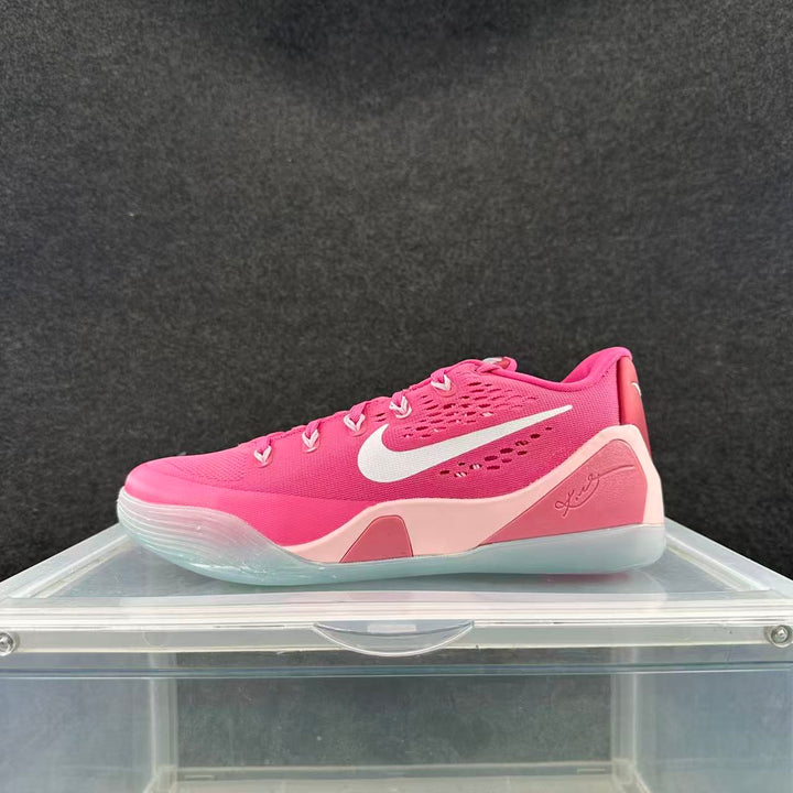 Side view of a pink Nike low-top basketball shoe with a white swoosh, pale pink accents, and a translucent-looking outsole.