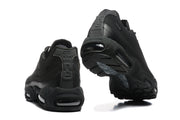 Rear and underside views of black Nike sneakers, showing heel branding, visible air units and outsole pattern.