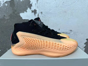 Side profile of a black Adidas AE 1 shoe showing a textured peach-orange panel and pink heel detail.