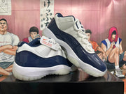 Two navy and white low-top sneakers displayed at an angle, showing the sides and outsoles.