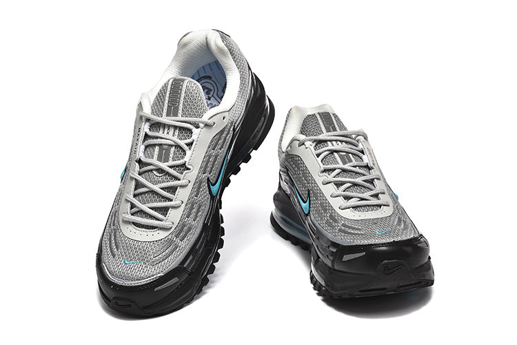 Pair of grey and black Nike Air Max 97-style sneakers with turquoise accents, shown from the front