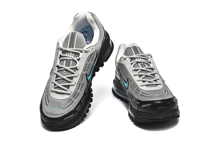 Pair of grey and black Nike Air Max 97-style sneakers with turquoise accents, shown from the front
