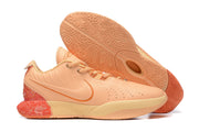 Peach Nike basketball shoes with coral accents and a matching patterned outsole.