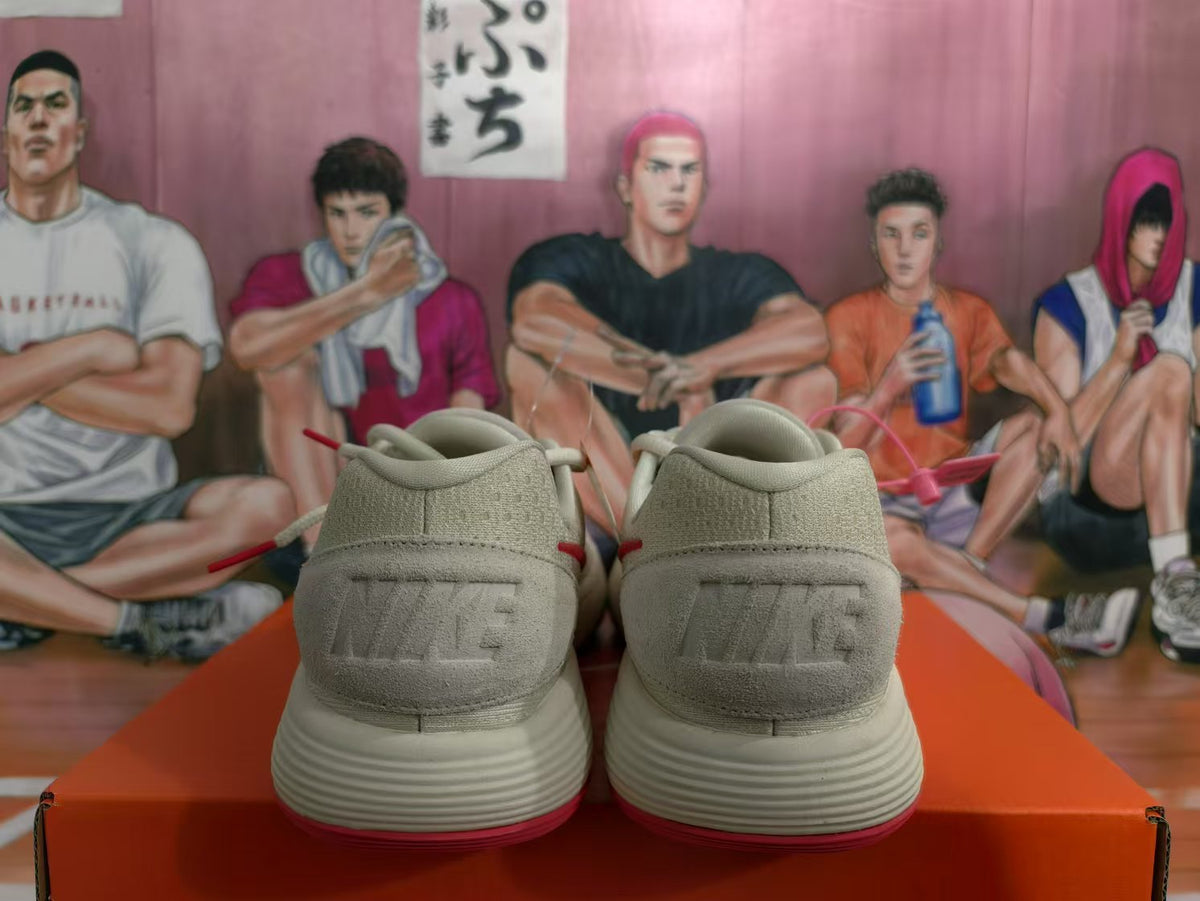 Rear view of white Nike sneakers showing embossed heel branding, red outsole accents, and a textured upper.