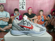 Side view of one grey and red Nike sneaker showing the textured upper, red Swoosh, overlays, and Nike Zoom midsole branding.