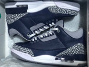 Pair of navy and grey Air Jordan 3-style sneakers with elephant-print overlays, shown in a box.