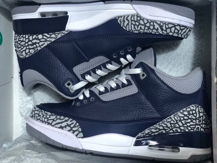 Pair of navy and grey Air Jordan 3-style sneakers with elephant-print overlays, shown in a box.