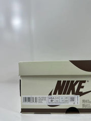 Nike shoebox label showing Air Jordan 1 Low OG, style code DM7866 600, EU 42, US 8.5, UK 7.5, and CM 26.5.