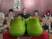 Rear view of a pair of bright green sneakers showing the molded heel shape and layered ribbed detailing.