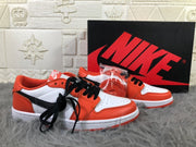 Pair of low-top sneakers shown from the front and side with black laces and an extra orange lace set.