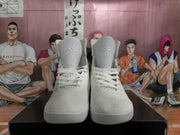 Front view of white high-top basketball sneakers with textured uppers and raised ankle collars.