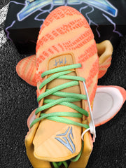 Close-up of the sneaker tongue, green laces, yellow trim, and visible Nike basketball-style logo.