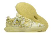 Pale yellow patterned Nike basketball shoe with a matching outsole.