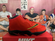 Side profile of a red and black Nike high-top basketball shoe with yellow-outlined side detailing.