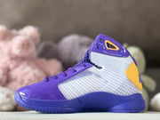 Opposite side view showing the purple upper, silver patterned side panel, and gold heel accent.