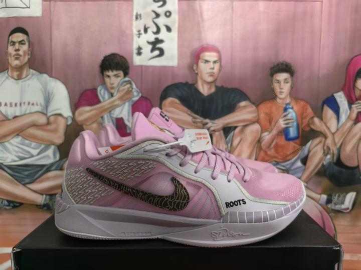 Pair of pink and gray Nike basketball sneakers shown from the side on a shoebox.