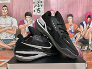 Angled view showing the textured black uppers, white side Swoosh branding, and layered midsoles.