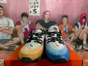 Front view of the mismatched Nike sneakers, showing white tongues, black laces, and blue and orange toe areas.