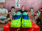 Front view of the yellow and blue Nike sneakers, showing the patterned toe boxes, blue laces, and striped blue-and-yellow tongues.