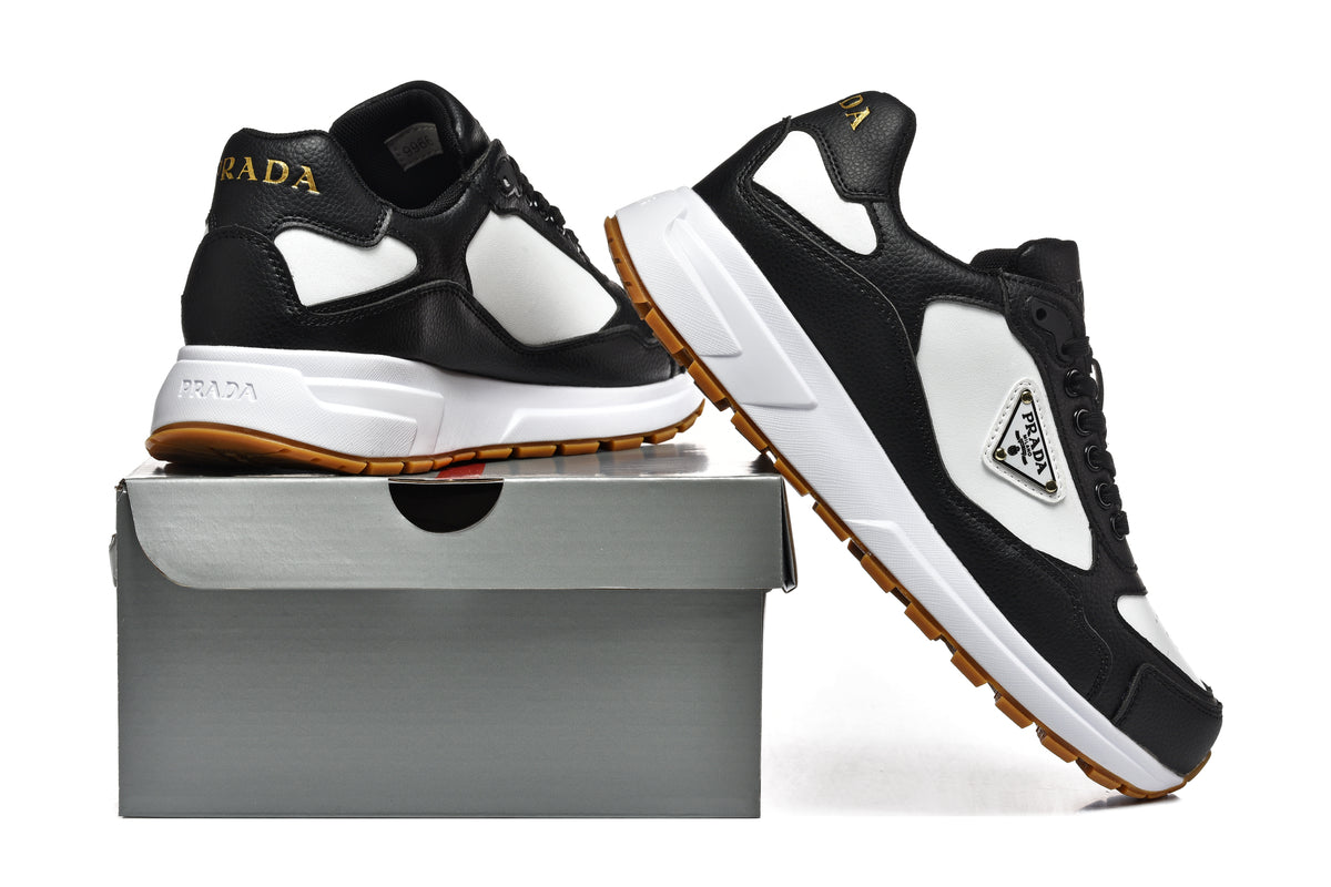 Black and white Prada low-top sneakers shown from the side on a box