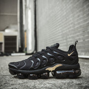 Side profile of a black and gold Nike TN-11 sneaker