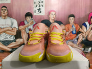 Front view of pink basketball sneakers with yellow laces and yellow outsoles