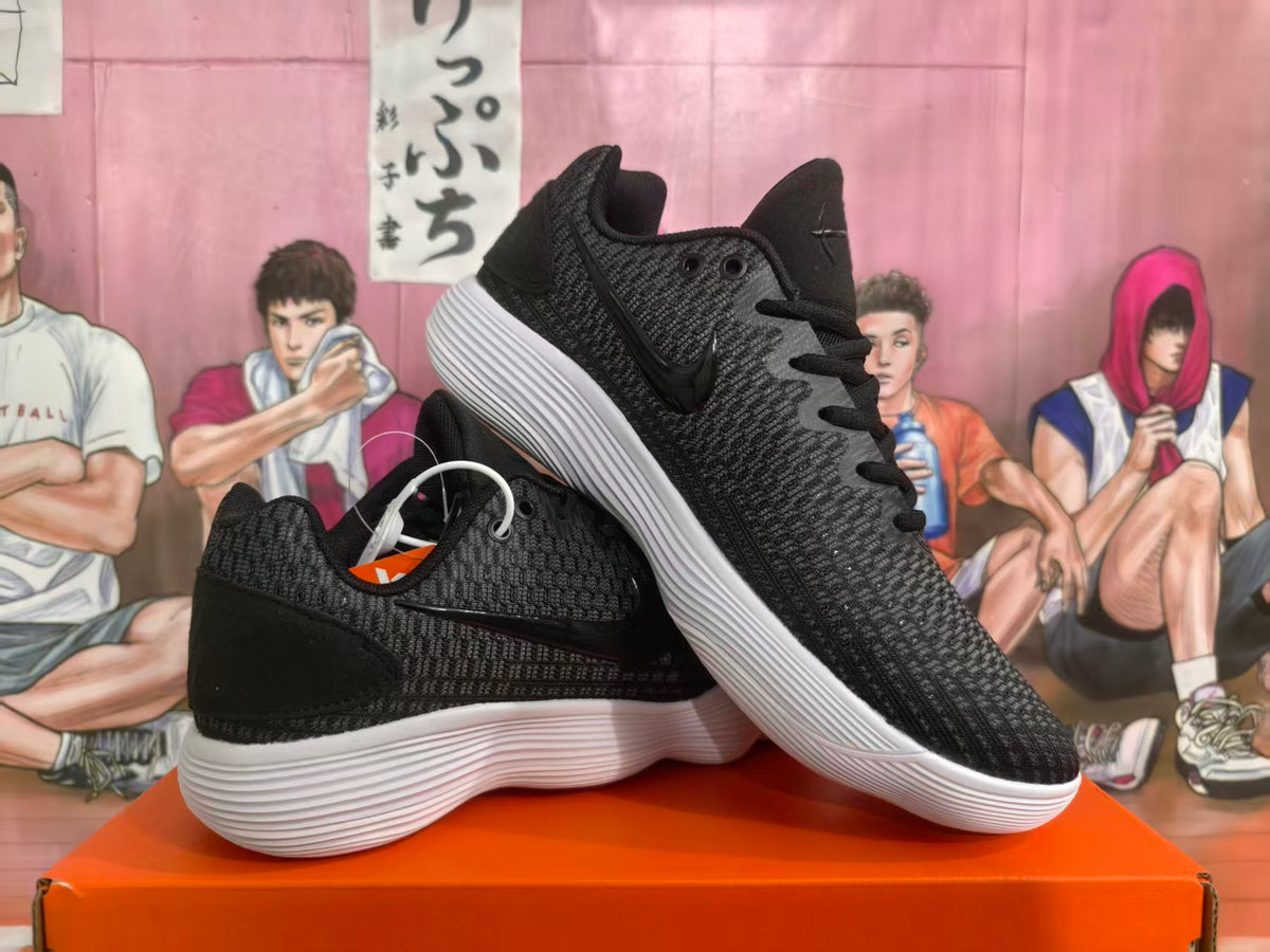 Black low-top sneakers with a textured upper and white ridged soles, shown at an angle.