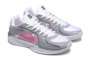 Close view of the pair of white and grey basketball shoes with pink side accents.