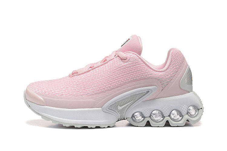 Side view of a pink Nike running-style sneaker with a white sole and round heel pods.
