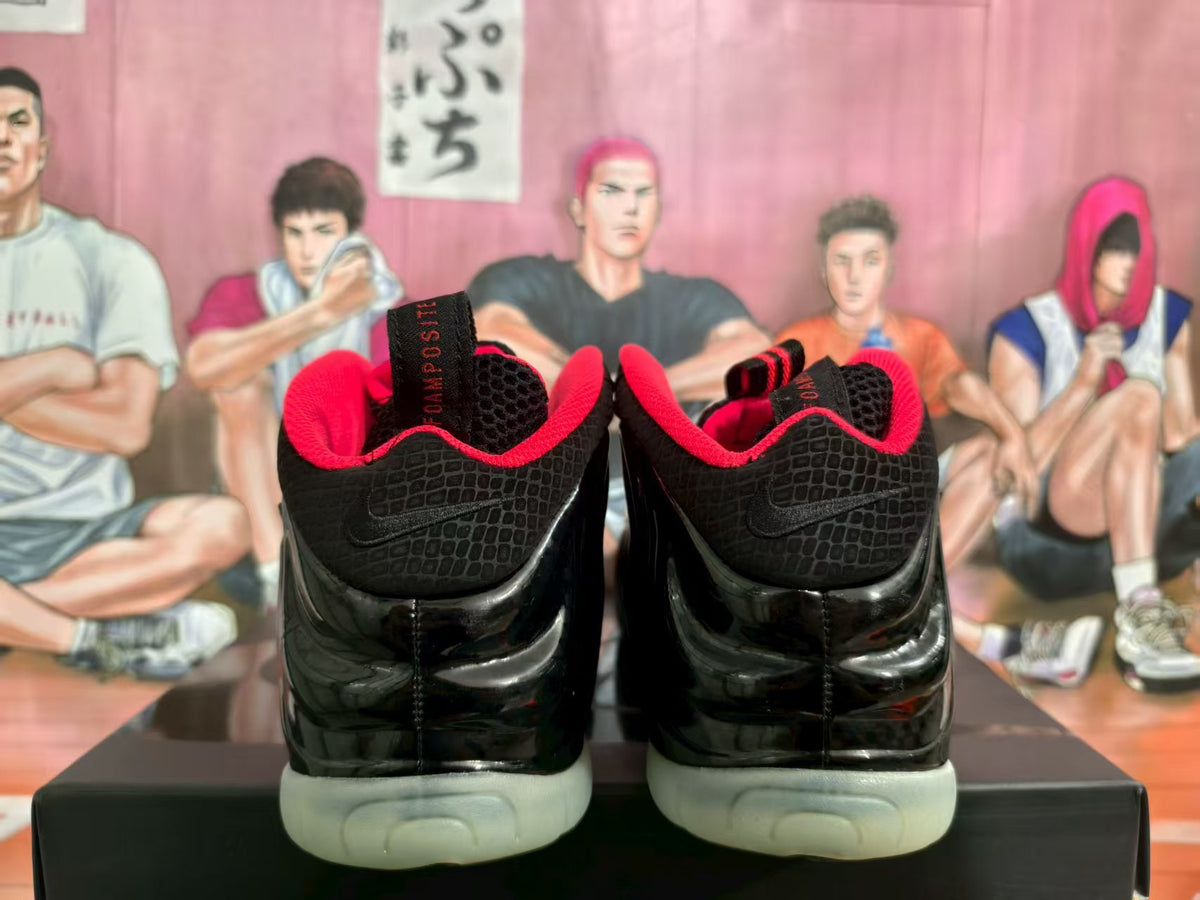 Rear view of black Nike sneakers with red lining, glossy uppers, and pale translucent soles.