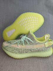 Side view of a green and black patterned sneaker with a contrasting stripe and translucent green-toned sole.