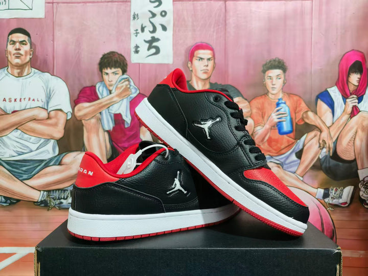 Pair of black and red Jordan low-top sneakers displayed on a shoebox.