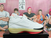 Side view of a white Jordan low-top shoe with a textured side logo and contrasting red and black outsole.