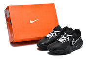 Black Nike basketball sneakers with white laces displayed beside an orange Nike shoe box.