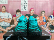 Front view of the teal basketball sneakers with black patterned overlays and padded tongues.