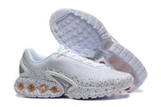 Nike Air Max DN SE PRM sneakers shown from the side with one shoe outsole visible.