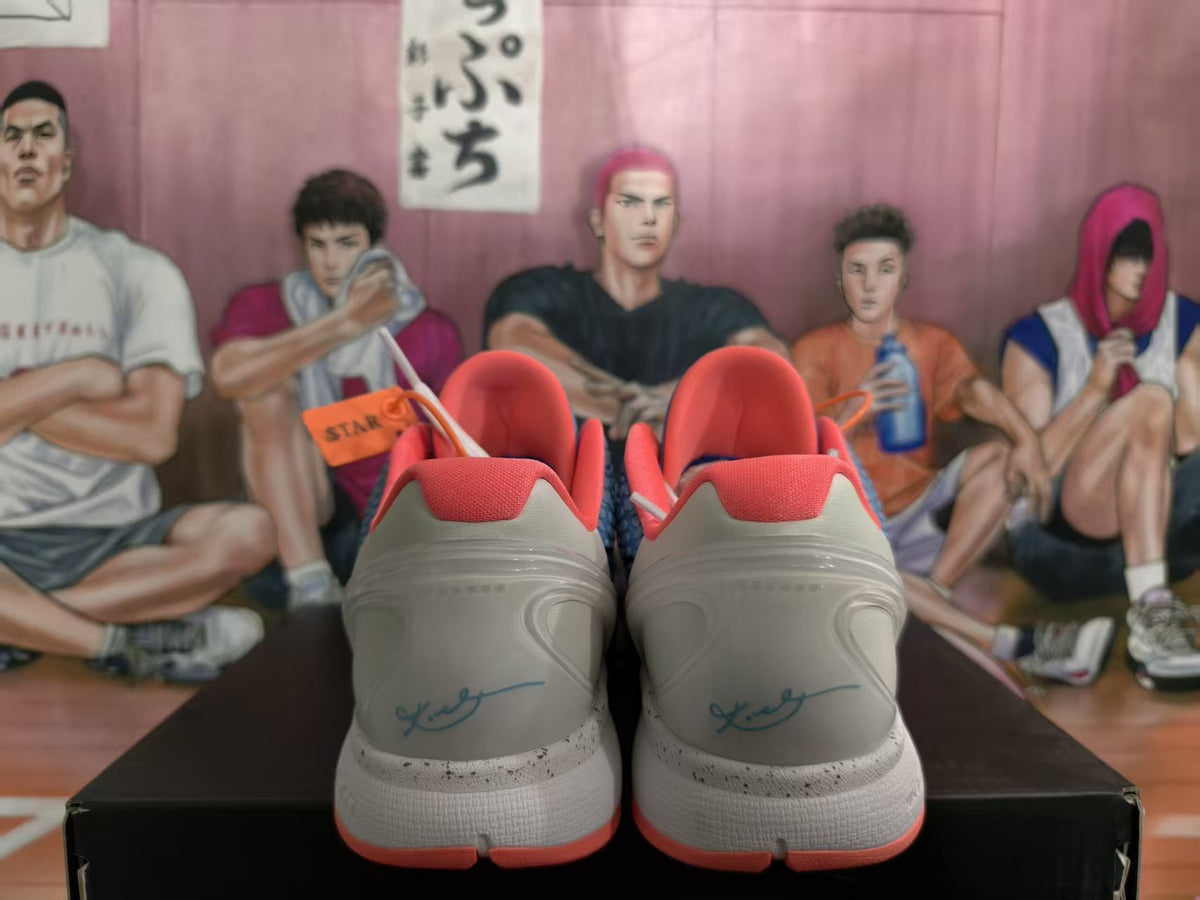 Rear view of blue and white Nike basketball sneakers with coral-pink collars, white midsoles, and coral outsole accents.