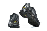 Black Nike Air Max Plus sneakers shown from the heel and outsole.