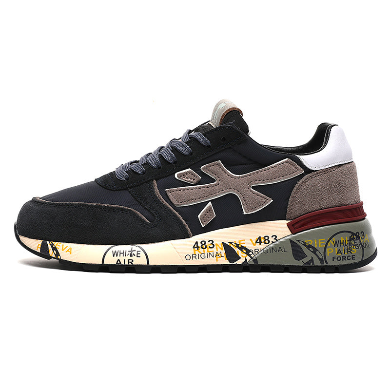 Side view of black low-top sneakers with taupe details, gray laces, a white heel panel, and a printed sole.