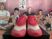 Front view of pink Nike basketball sneakers with light contrasting panels and lace-up fastening.