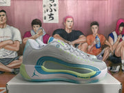 Lateral side view of a gray Jordan basketball sneaker with blue and green detailing and a visible Jumpman logo.