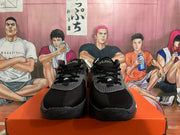 Front view of black Nike basketball shoes with lace-up closures and gray patterned overlays.