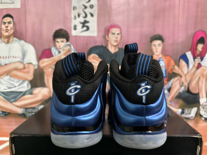 Rear view of blue and black high-top sneakers with heel logos and light-colored outsoles.